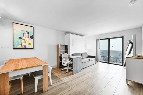 a living room with furniture a flat screen tv and a table