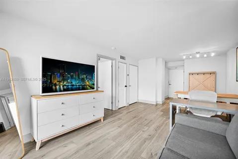 a living room with stainless steel appliances furniture a fireplace and wooden floor