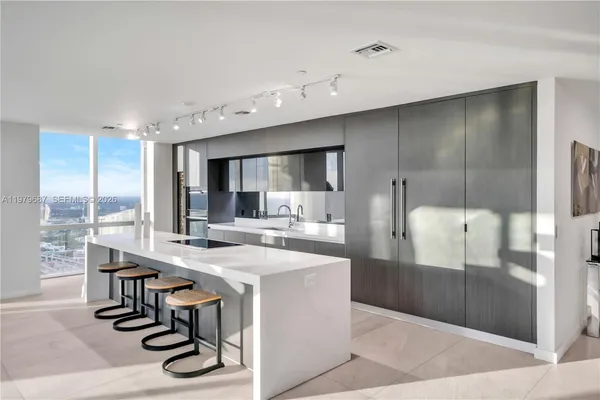 a kitchen with a table chairs refrigerator and cabinets
