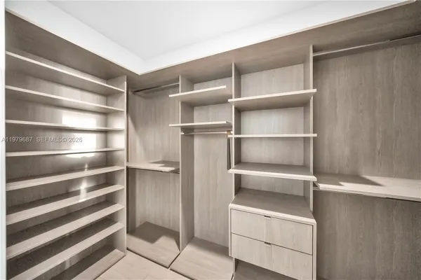 a view of walk in closet with empty racks