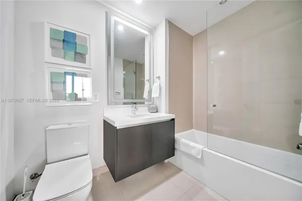 a bathroom with a bathtub sink mirror vanity and toilet