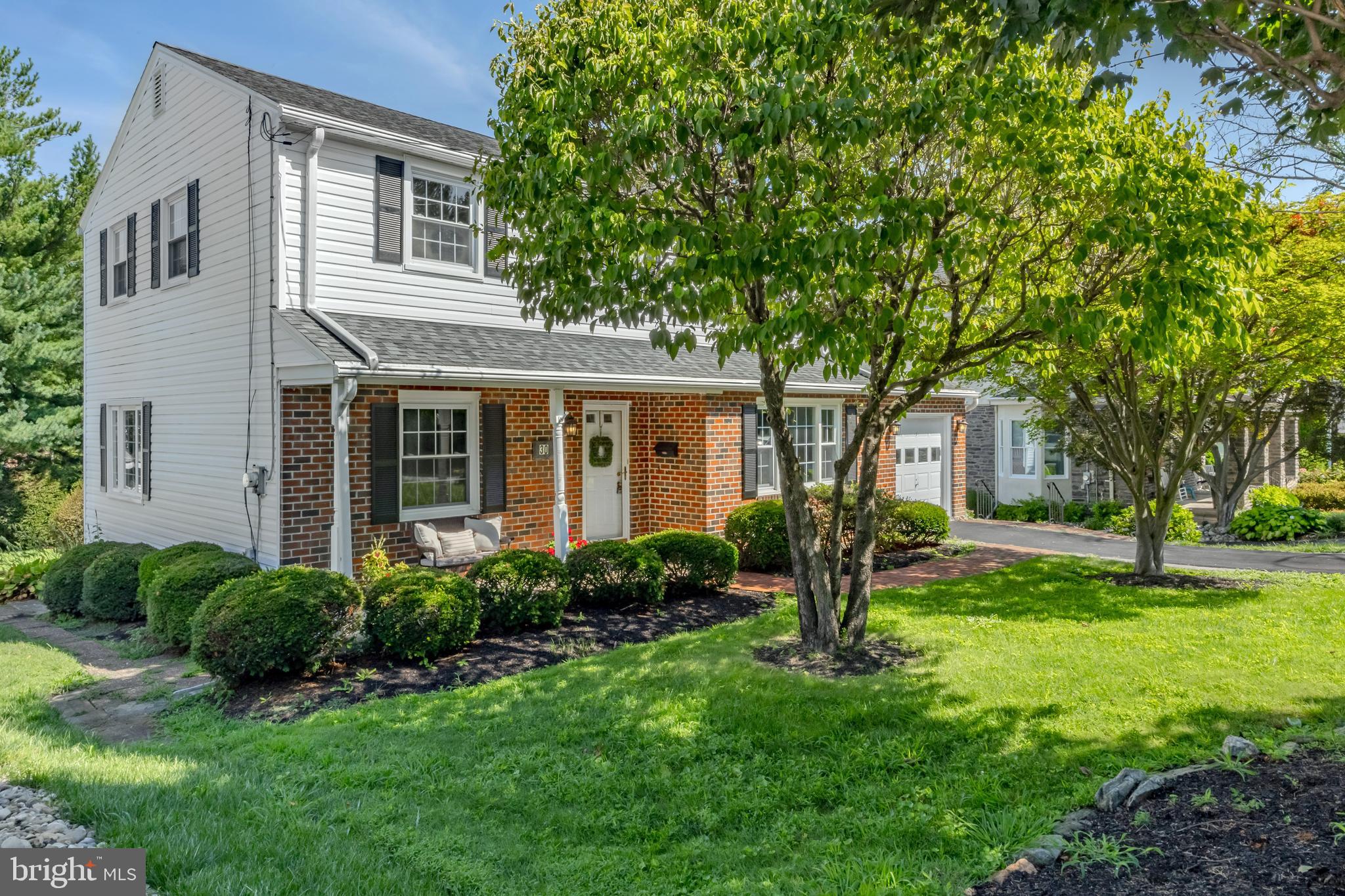 a front view of a house with yard and green space