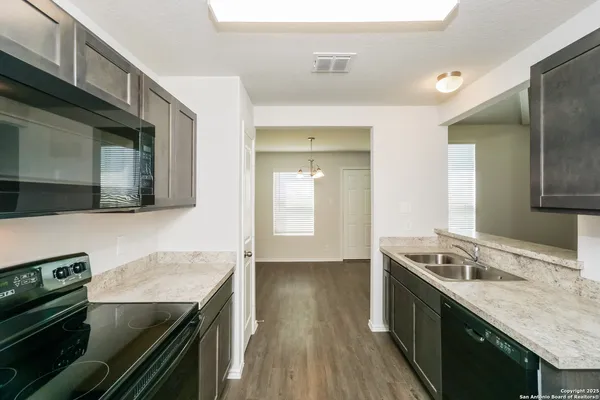 a kitchen with granite countertop a stove and a sink