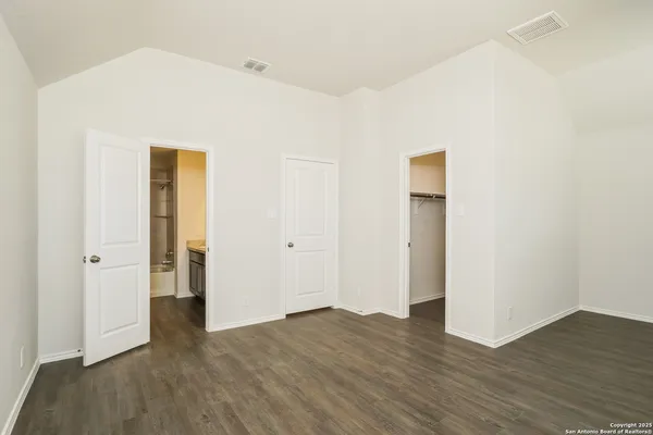 an empty room with wooden floor and closet