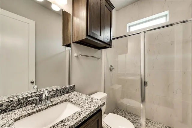 a bathroom with a granite countertop sink toilet and shower