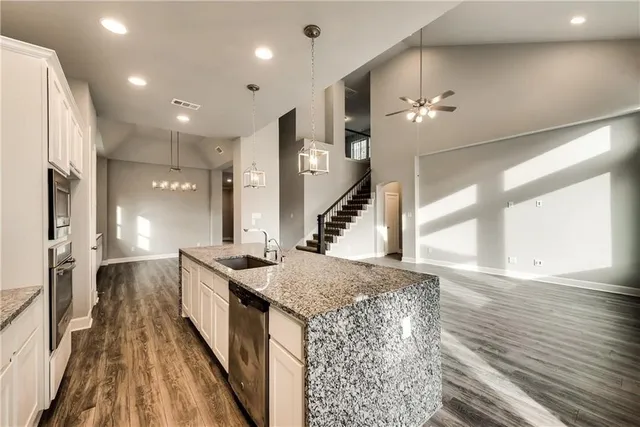 a spacious bathroom with a granite countertop sink a mirror and shower