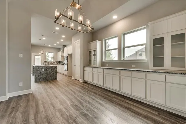 a view of a large kitchen with a sink and wooden floor