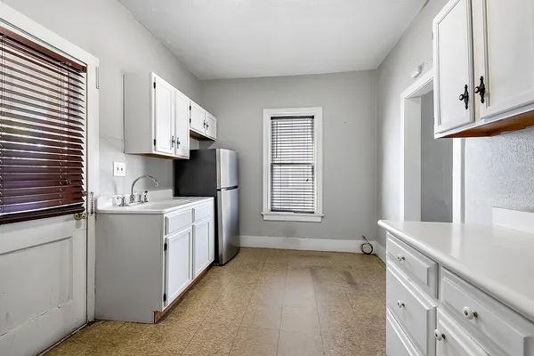 a kitchen with granite countertop a sink stove and cabinets