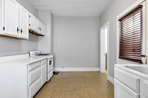 a kitchen with granite countertop white cabinets and white appliances