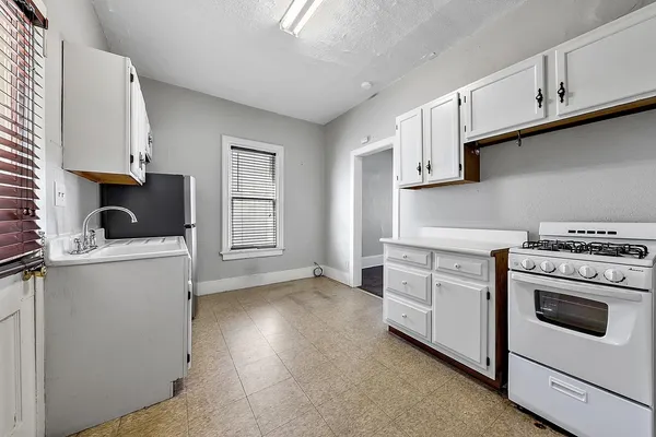 a kitchen with white cabinets and white appliances