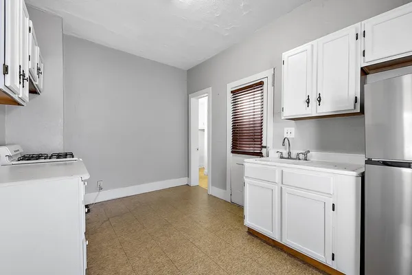 a kitchen with cabinets appliances a sink and a window