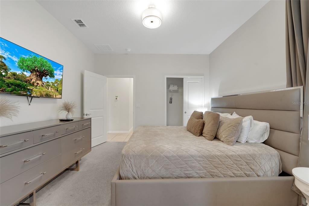 4450 Kaipo Road Davenport, FL 33897 - Photo 14 of 66 a bedroom with a large bed and a flat screen television