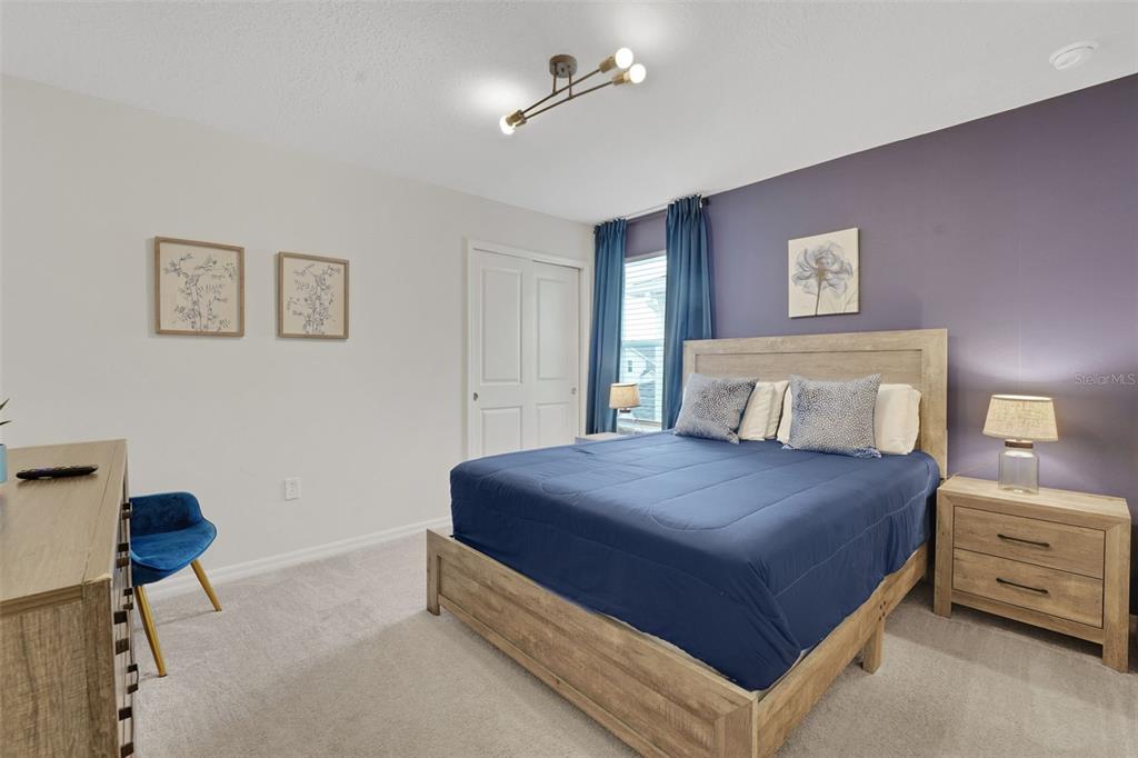 4450 Kaipo Road Davenport, FL 33897 - Photo 28 of 66 a bedroom with a bed and a chandelier