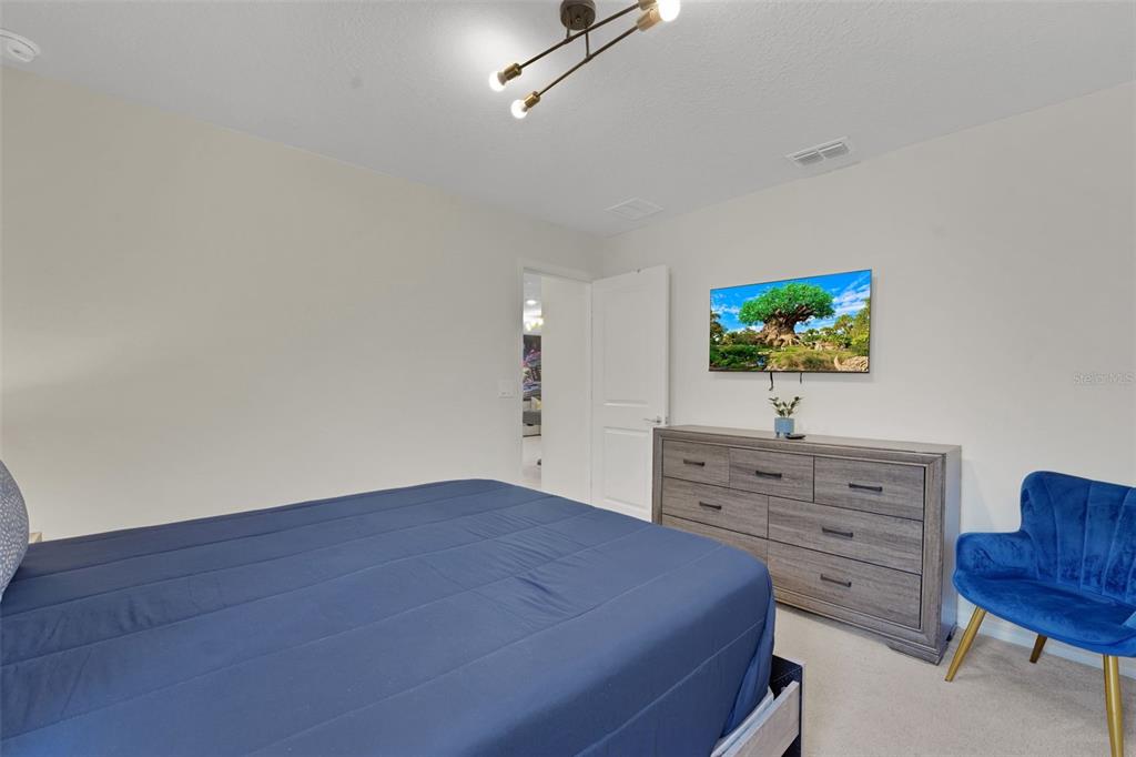 4450 Kaipo Road Davenport, FL 33897 - Photo 29 of 66 a view of a bedroom with furniture and flat screen tv