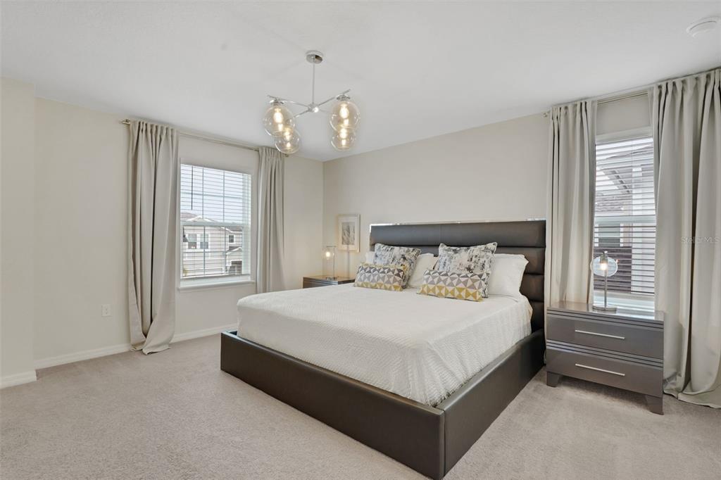 4450 Kaipo Road Davenport, FL 33897 - Photo 32 of 66 a large bed sitting in a bedroom next to a window and chandelier