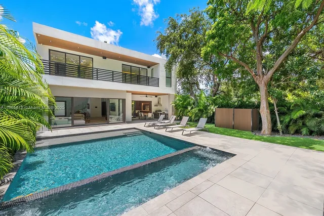 a front view of a house with swimming pool having outdoor seating