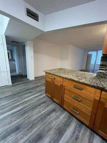 a hallway with granite countertop wooden floor