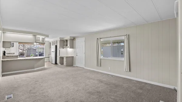 a view of living room with stainless steel appliances granite countertop furniture and a window