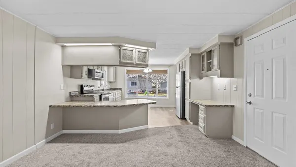 a kitchen with stainless steel appliances granite countertop a stove a sink and a microwave