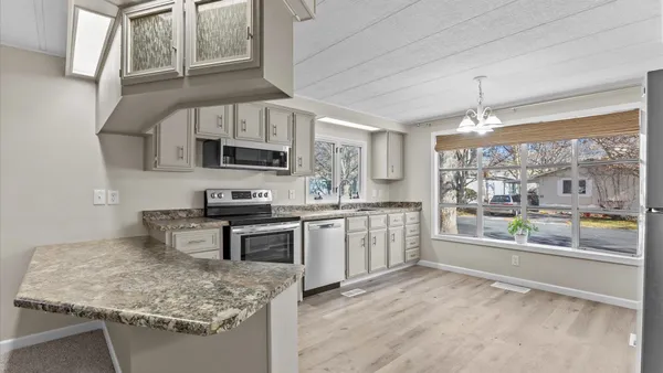 a kitchen with granite countertop a refrigerator and a sink