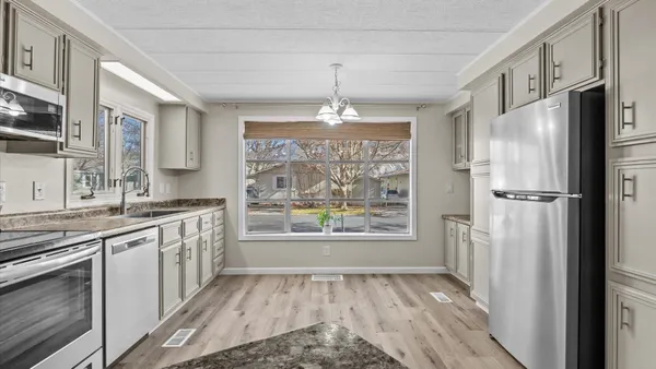a kitchen with a refrigerator a sink and cabinets