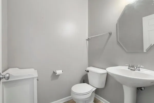 a bathroom with a sink a toilet and a mirror