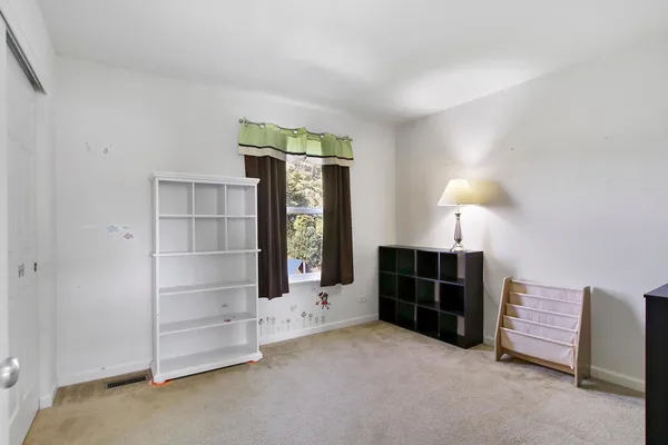 a view of an empty room with a fireplace and a window