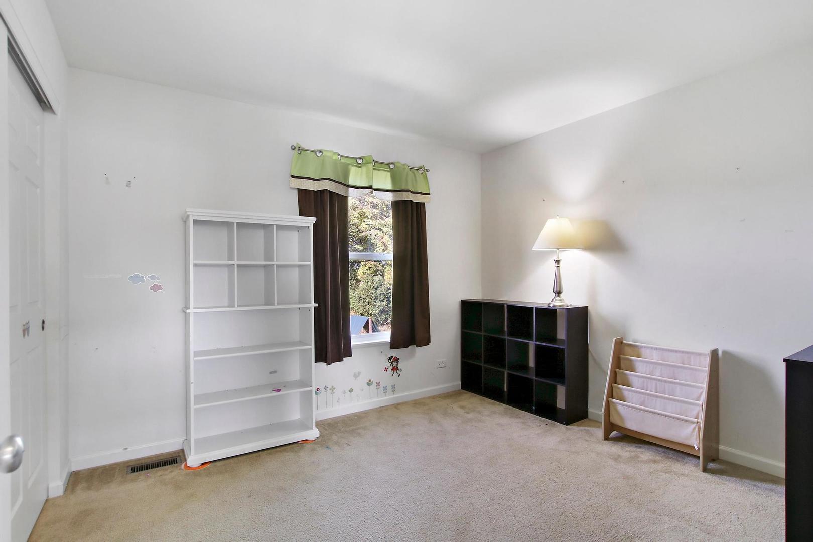 1230 Bellows Way Volo, IL 60073 - Photo 24 of 32 a view of an empty room with a fireplace and a window