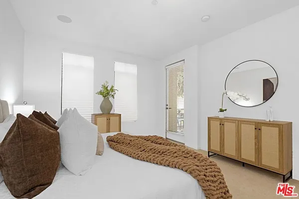 a bedroom with a bed a dresser and mirror
