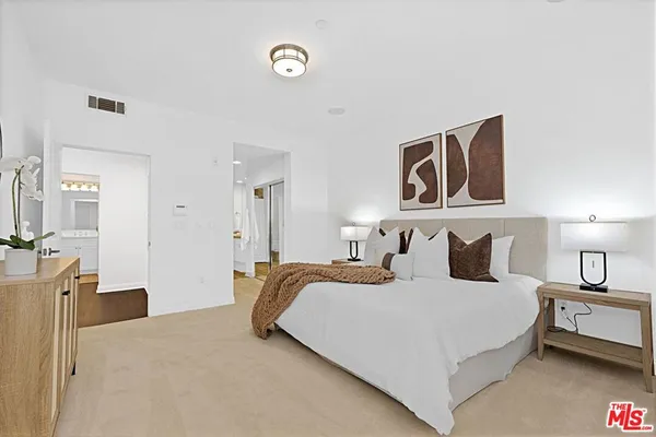 a bedroom with two beds and painting on the wall