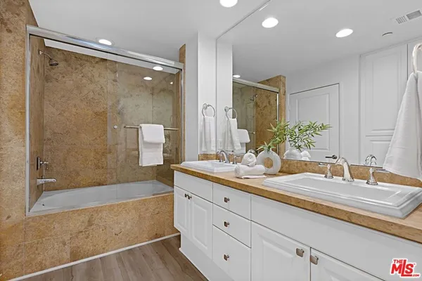 a bathroom with a granite countertop sink mirror and a bath tub