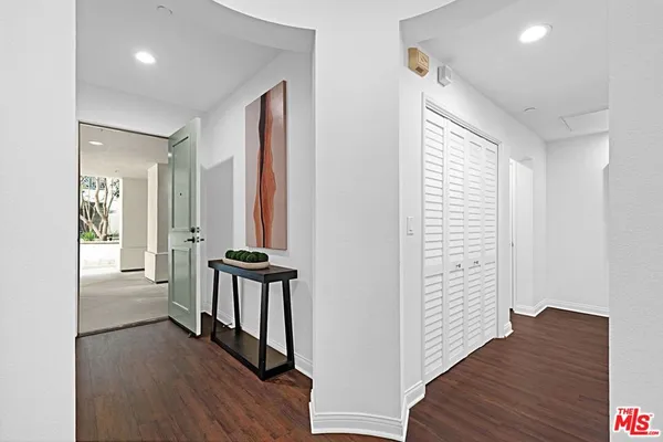 a view of a hallway with wooden floor and windows