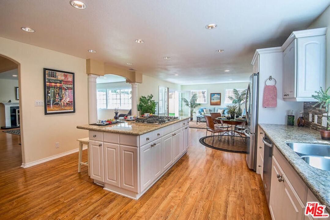 7830 West 83rd Street Playa del Rey, CA 90293 - Photo 22 of 74 a large kitchen with stainless steel appliances granite countertop a lot of counter space and wooden floors