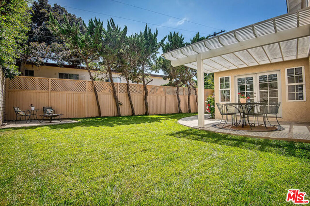 7830 West 83rd Street Playa del Rey, CA 90293 - Photo 50 of 74 a view of a backyard with table and chairs potted plants and large tree