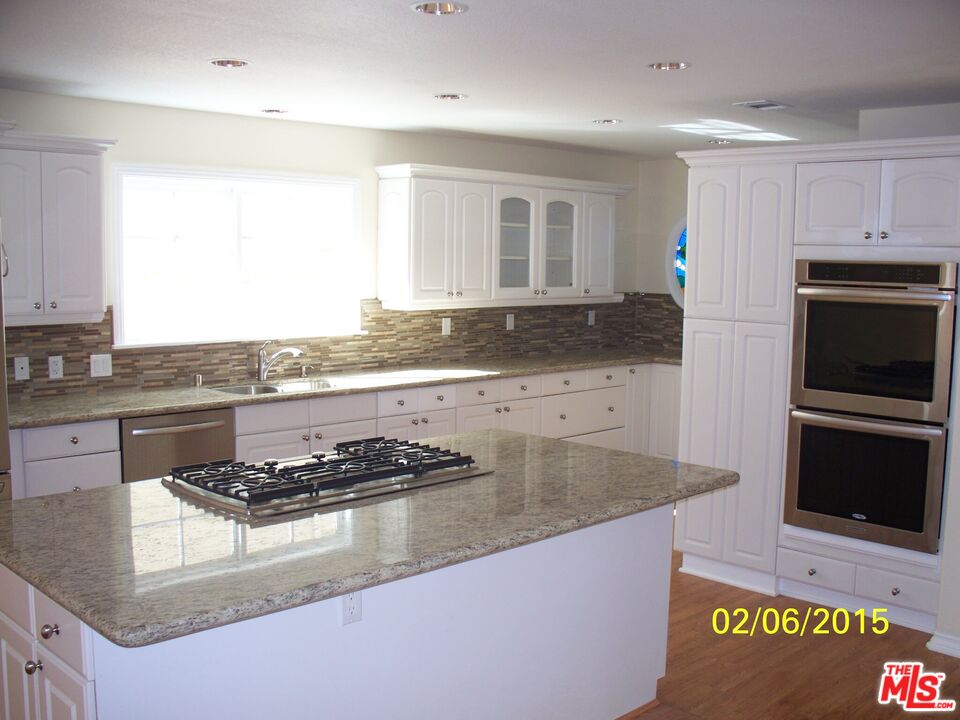 7830 West 83rd Street Playa del Rey, CA 90293 - Photo 63 of 74 a kitchen with granite countertop a stove a sink and a microwave