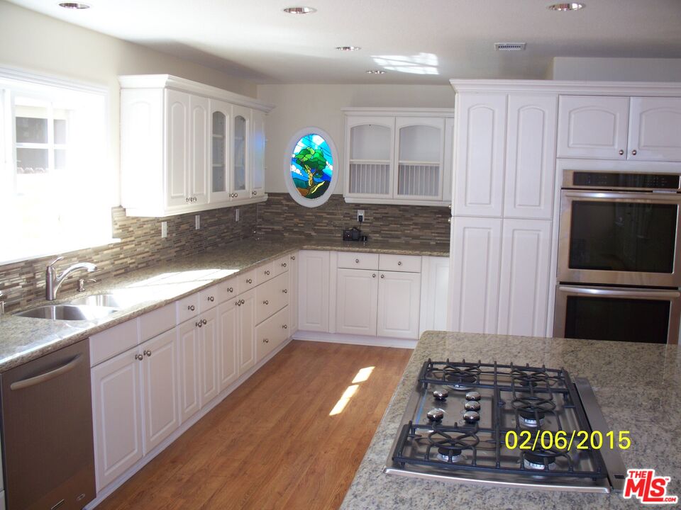 7830 West 83rd Street Playa del Rey, CA 90293 - Photo 64 of 74 a kitchen with stainless steel appliances granite countertop a stove a sink and a granite counter tops with white cabinets