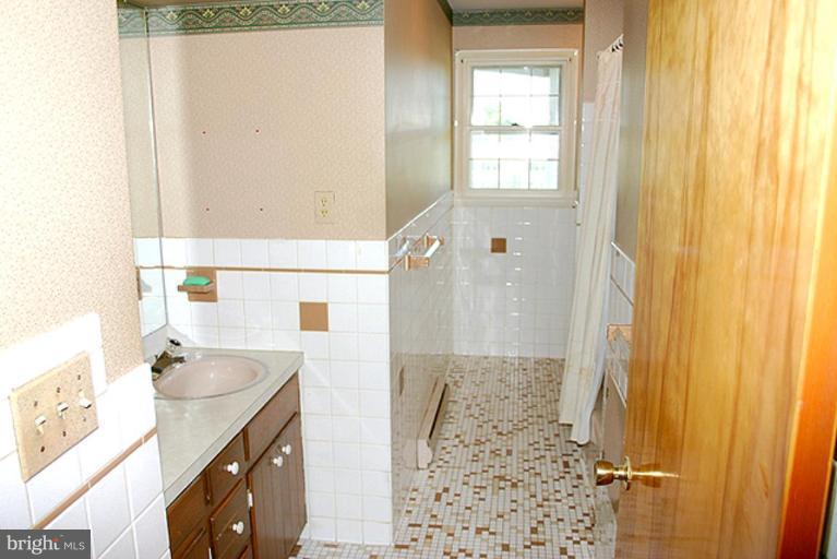 1907 Ridgewood Court Hampstead, MD 21074 - Photo 12 of 25 a bathroom with a sink a mirror and a shower