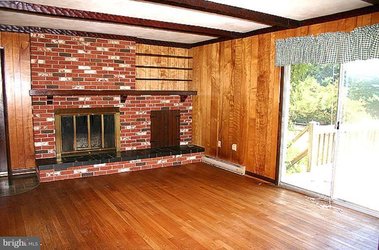 1907 Ridgewood Court Hampstead, MD 21074 - Photo 4 of 25 a view of an empty room with wooden floor and a window