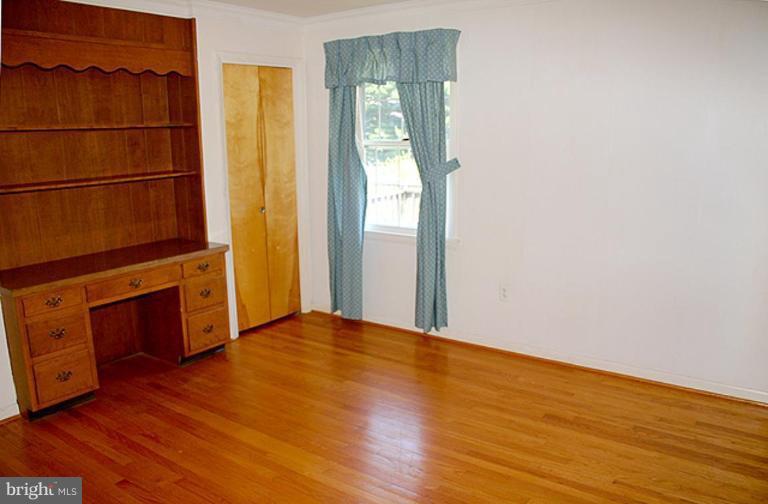 1907 Ridgewood Court Hampstead, MD 21074 - Photo 9 of 25 a view of an empty room with wooden floor and a window