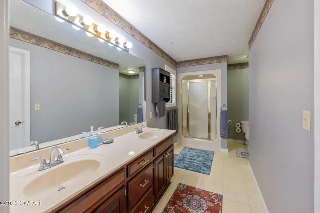 a spacious bedroom with a bed and a flat screen tv