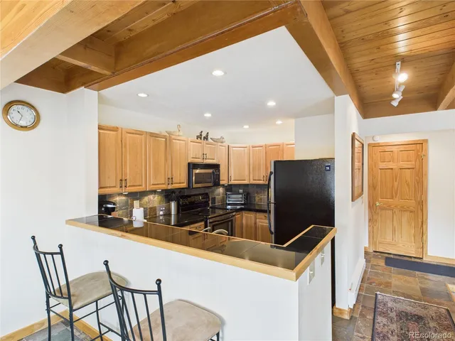 a kitchen with stainless steel appliances a microwave a stove and white cabinets with wooden floor