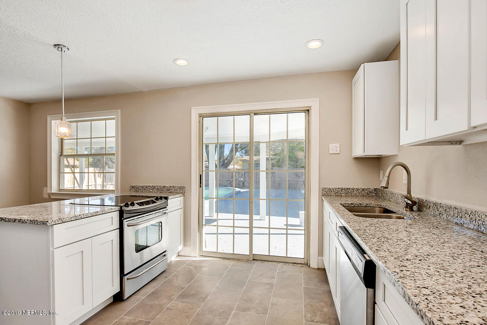 2627 Lorna Road Jacksonville, FL 32211 - Photo 17 of 30 a kitchen with stainless steel appliances granite countertop a stove a sink and a microwave