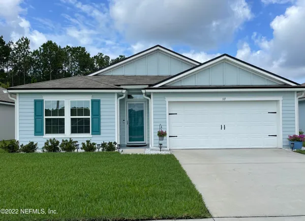 a front view of a house with a yard and garage