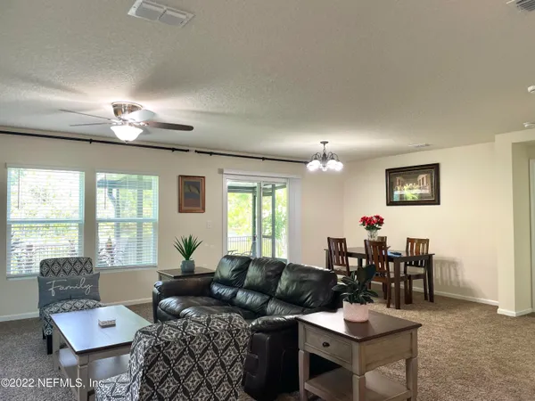 a living room with furniture a chandelier and a window