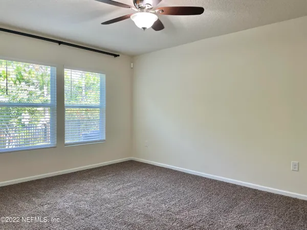an empty room with a window and a fan