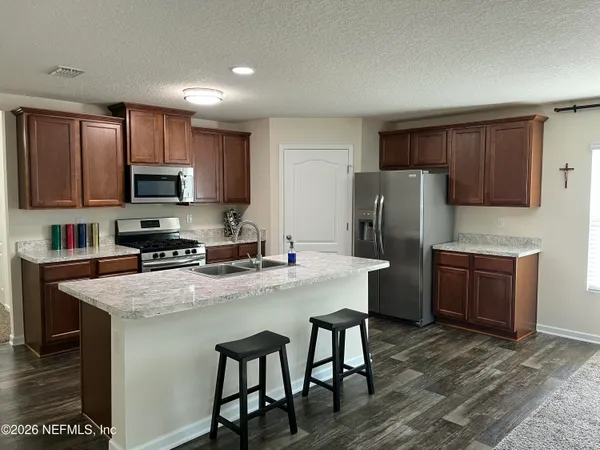 a kitchen with stainless steel appliances granite countertop a refrigerator stove microwave and sink