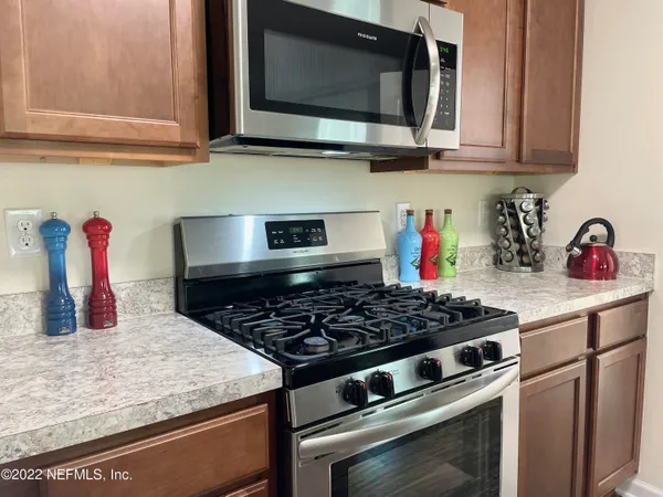 a kitchen with stainless steel appliances granite countertop a stove and a microwave