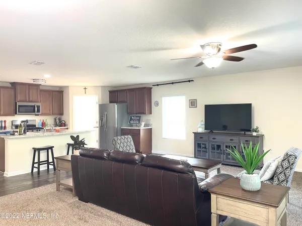 a living room with furniture kitchen view and a potted plant