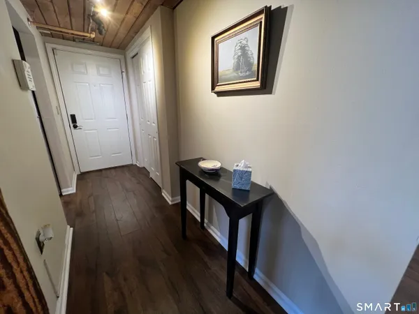 a view of a hallway with wooden floor and staircase