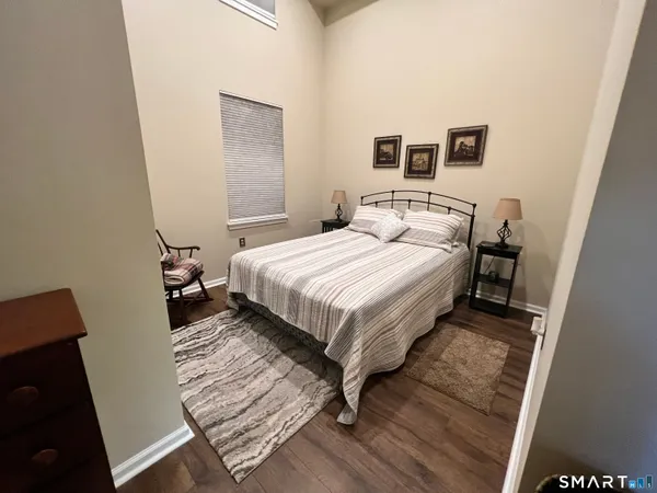 a bedroom with a bed and wooden floor